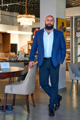 A stylish bearded man in a business suit in an interior