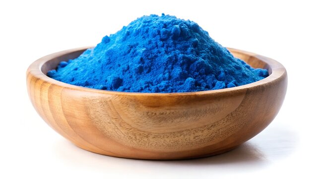 Bright blue spirulina powder pile in wooden bowl isolated on white