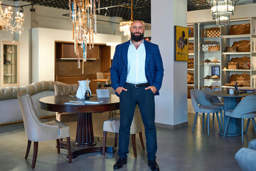 A stylish bearded man in a business suit in an interior