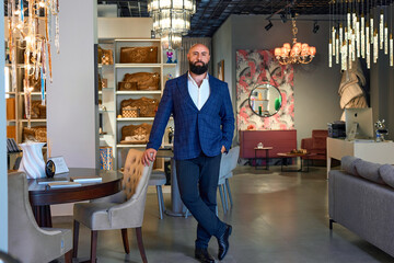 A stylish bearded man in a business suit in an interior