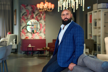 A stylish bearded man in a business suit in an interior