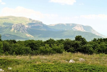 Beautiful mountain landscape featuring verdant hills and a clear blue sky. Crimea, Ukraine