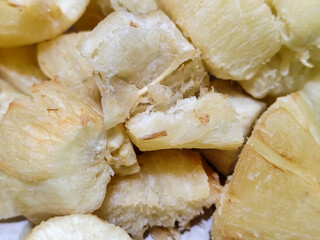 Fried cassava, golden yellow in color and crispy texture can be seen filling the entire frame, showing details of the fibers and soft inside