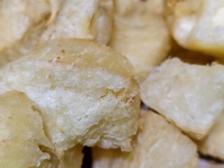 Fried cassava, golden yellow in color and crispy texture can be seen filling the entire frame,...