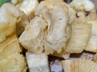Fried cassava, golden yellow in color and crispy texture can be seen filling the entire frame,...