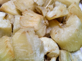 Fried cassava, golden yellow in color and crispy texture can be seen filling the entire frame,...