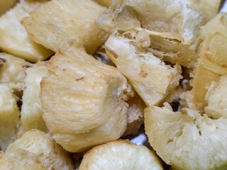 Fried cassava, golden yellow in color and crispy texture can be seen filling the entire frame,...