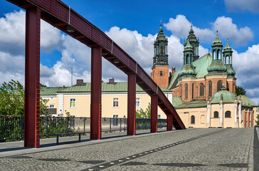 The towers of the Gothic cathedral and the steel structure of the bridge over the Warta River in Poznan