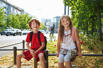 Children cross the street with rucksacks near school. Back to school together.