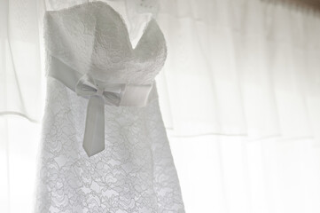 Elegant White Lace Wedding Dress with Ribbon Belt on Display