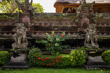 Monkey sculpture fully covered with green moss in Ubud's Monkey Forest. Bali, Indonesia.