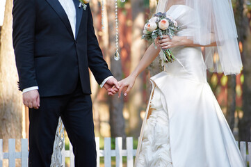Elegant Bride and Groom Holding Hands During Outdoor Wedding Ceremony