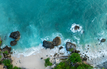 Top Aerial view of impossible Beach in Bali, Indonesia. Empty paradise beach, blue sea waves in...