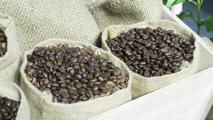 A burlap sack filled with dark roasted coffee beans