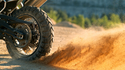 Flying rocks and dust from the wheel of a motocross bike at the start of the race