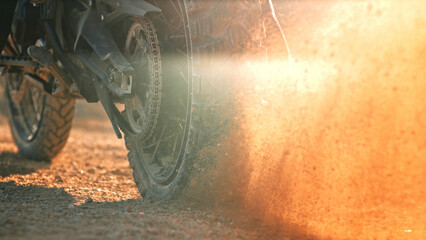Flying rocks and dust from the wheel of a motocross bike at the start of the race