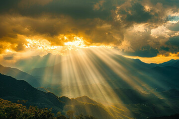 Golden sunlight breaking through the clouds above a mountainous landscape, casting a warm, ethereal glow over the peaks and valleys