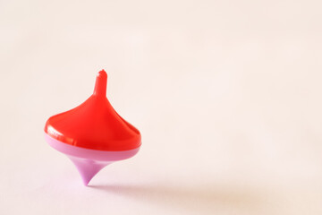 pink and red spinning top spinning on a wooden table