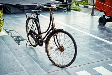 Gordijnen Stylish gold-black coloured bicycle parked on the street of Bali, Indonesia © luengo_ua
