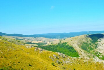 Beautiful mountain landscape featuring verdant hills and a clear blue sky. Crimea, Ukraine