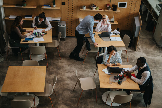 Professionals engaged in teamwork and discussions in a rustic-style co working office, fostering creativity and innovation.