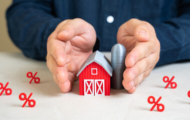 A man protects a farm barn from interest. High interest rates, taxes and costs are hurting the...