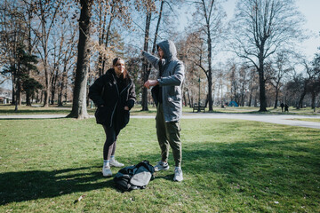 Two teenagers dressed in casual clothing talking and bonding outdoors in a serene park. The late...