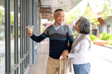 Happy senior asian couple shopping together enjoying retirement travel lifestyle in holiday trip, financial planning goals, elderly healthcare insurance, healthy aging and senior tourism experience