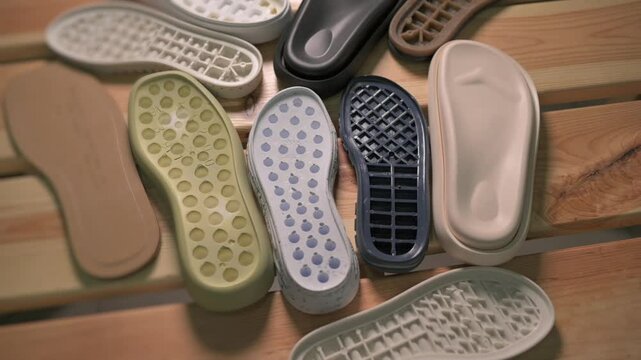 lots of shoe soles. A beautifully arranged collection of vibrant, colorful shoe insoles resting on a wooden surface