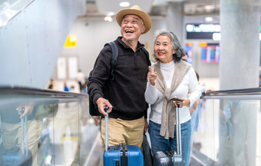 Senior asian traveler couple smiling at airport with suitcases show excitement before travel, retirement lifestyle, planning international journey, travel insurance for elderly, tour and global trip