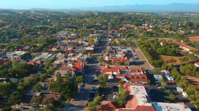 Smooth aerial zoom in revealing the charming architecture and urban layout of Solvang, a Danish-inspired town in Southern California during spring.