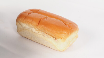 A loaf of soft and golden brown bread on white background.