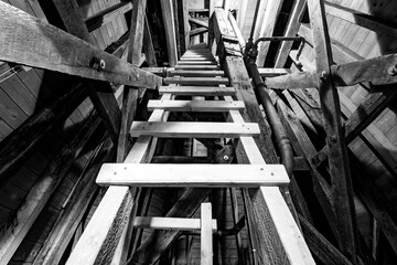 Wooden ladder leading to the top of a historic church spire. High contrast black and white shot...