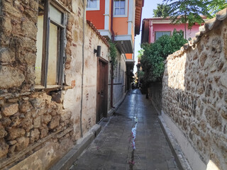 Obraz premium Narrow alleyway with a stone wall on one side