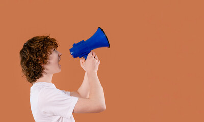 Young person using a blue megaphone to express excitement or make an announcement in front of a...