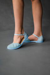 A woman is wearing stylish light blue shoes with ankle straps