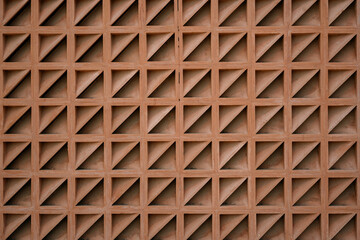 Terracotta breeze block wall with a repeating triangular pattern. Abstract geometric background...