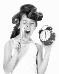 Cute little girl, morning, brush teeth, yawn, gape. Kid or girl with curler in hair hold alarm...