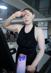 Real woman with a normal body working out on treadmill in gym. Realistic fitness and healthy weight...
