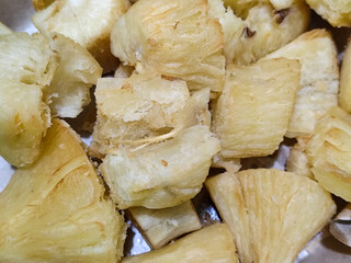 Fried cassava, golden yellow in color and crispy texture can be seen filling the entire frame,...