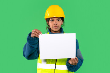 Construction worker holds blank sign in front of green background during a safety demonstration or...