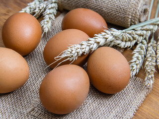 Fresh eggs laid out on burlap on a wooden table. 