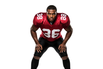 Male American football player in a red uniform in a ready crouch stance, looking determined