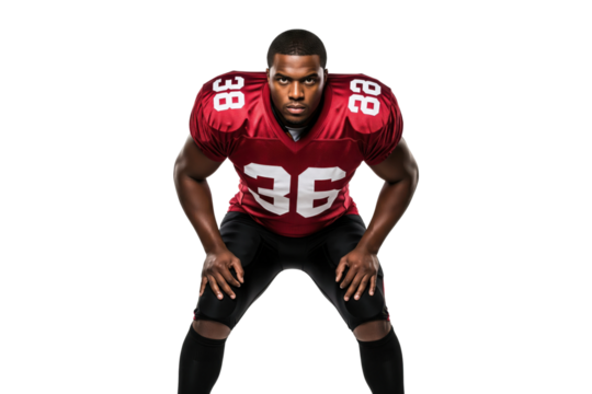 Male American football player in a red uniform in a ready crouch stance, looking determined - Powered by Adobe