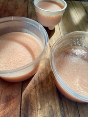 Strawberry milk pudding packaged in mica glass and blue round mold on a wooden table, pudding made from strawberry milk and jelly is a snack as a substitute for breast milk