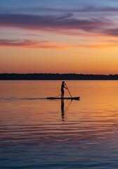 Silhouette of Person Paddleboarding at Sunset on Calm Water