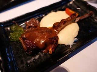 Gourmet Lamb Chop with Mashed Potatoes and Sauce on Black Plate
