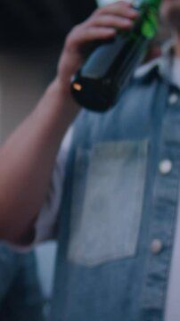 Young people engage in toast with bottles emphasizing commonness