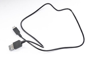 A black USB cable lies on a white surface, showing connectors.