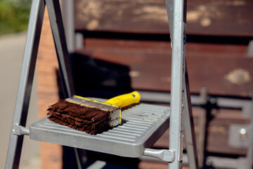 Painting Wood Fence with Paint Brush. Renewal and Renovation Old Wooden Fence. 